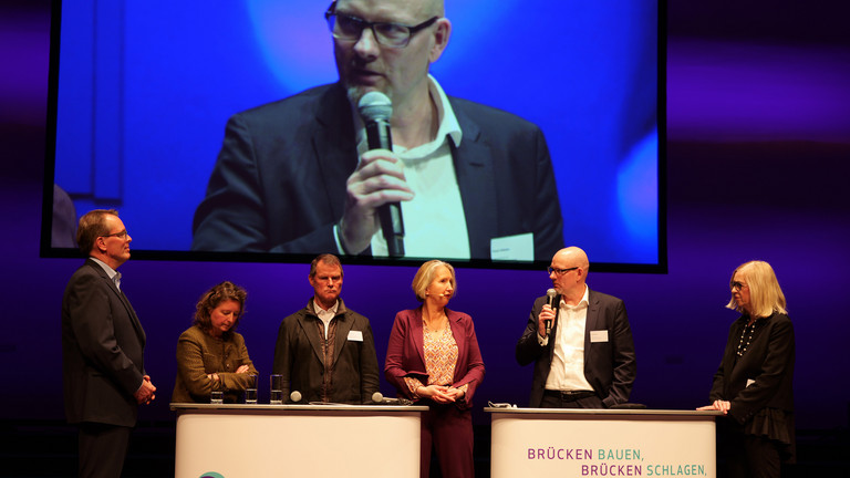 Frank Volkmer redet mit weiteren Vertreterinnen und Vertretern des Brandenburger Gesundheitswesens auf der Bühne