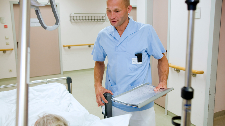 Pfleger beim Patienten am Bett - Pflege - Immanuel Klinikum Bernau