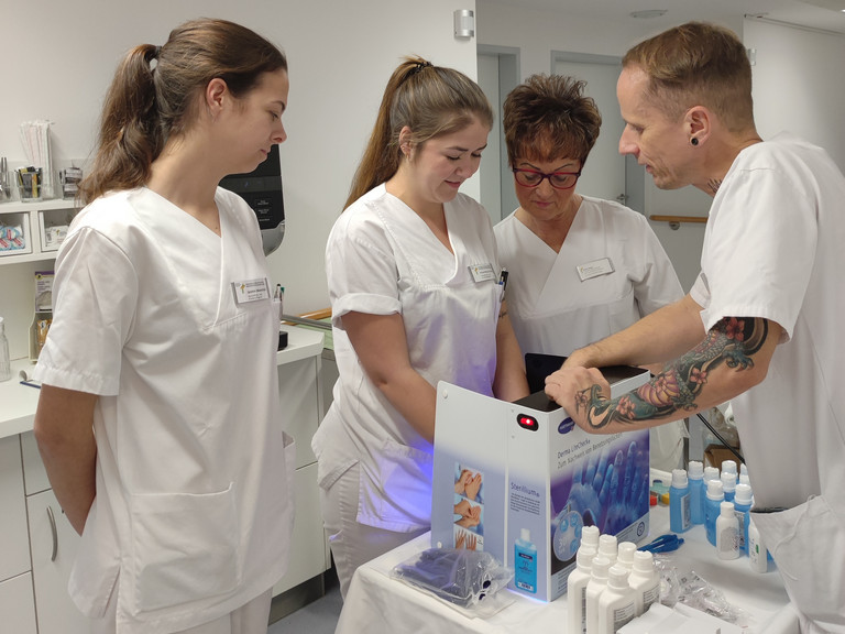 Pflegefachkräfte mit einer Hygienefachkraft an einer Desinfektionsstation beim Aktionstag Saubere Hände im Immanuel Klinikum Bernau Herzzentrum Brandenburg