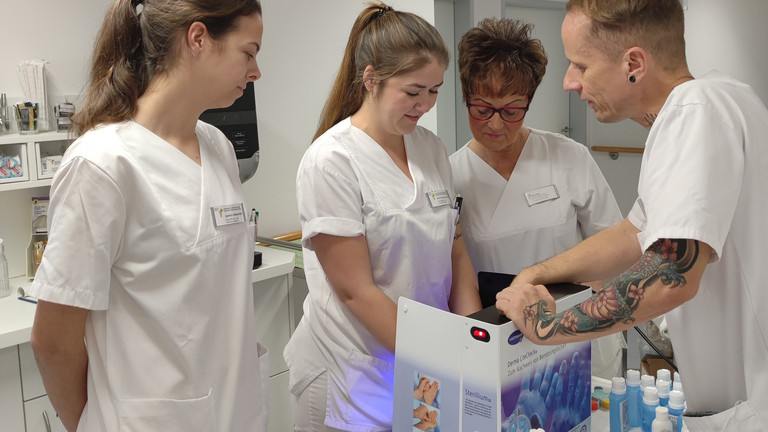 Pflegefachkräfte mit einer Hygienefachkraft an einer Desinfektionsstation beim Aktionstag Saubere Hände im Immanuel Klinikum Bernau Herzzentrum Brandenburg