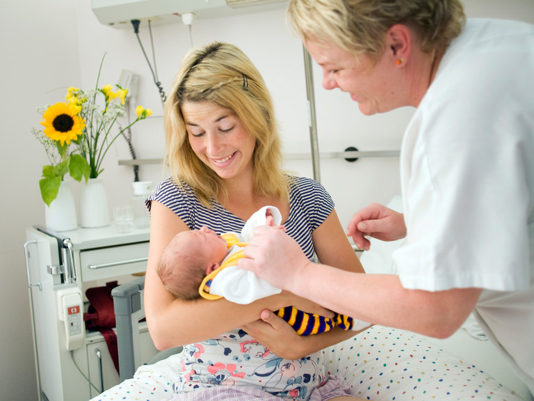Frau mit Baby im Arm und Pflegefachfrau - Immanuel Klinikum Bernau - Geburtshilfe