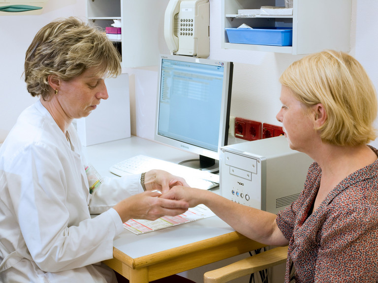 Ärztin untersucht Hand einer Patientin - Immanuel Klinikum Bernau - Versorgungsbereiche - Ambulante Behandlung