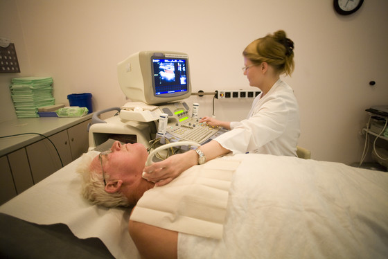 Auf dem Foto führt eine Ärztin Ultraschall bei einem Patienten durch Auf dem Foto führt eine Ärztin Ultraschall bei einem Patienten durch