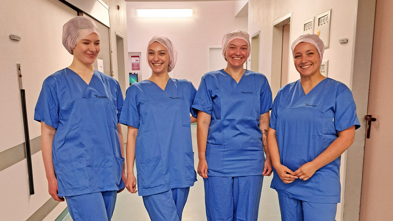 Die vier Auszubildenden Anästhesietechnischen Assistentinnen und Operationstechnische Assistentinnen stehen im Krankenhausflur nebeneinander, Start in die Praxis nach der Theorie, Immanuel Klinikum Bernau, Bernau bei Berlin