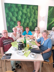 Ehemalige Mitarbeitende sitzen an einem Tisch mit Kaffee und Kuchen beim Ehemaligentreffen des Immanuel Klinikum Bernau