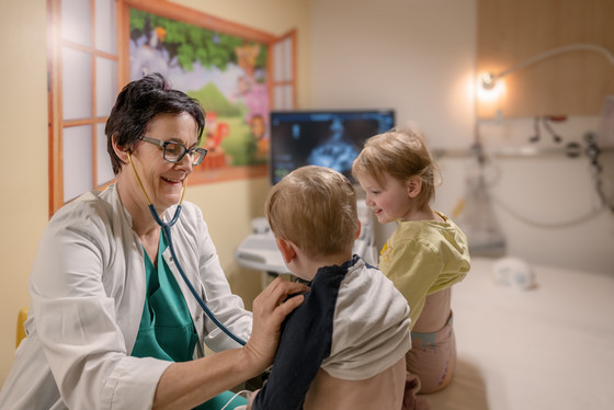 Auf dem Foto untersucht eine Kinderärztin junge Kinder