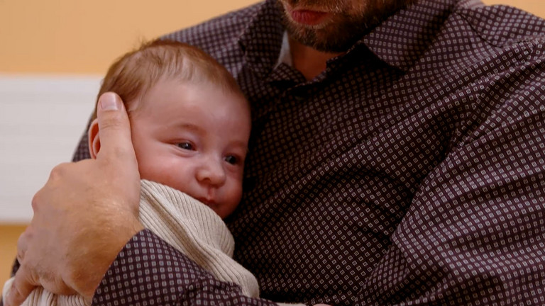 Ein Vater hält sein neugeborenes Kind auf dem Arm, Aufklärungsvideo für werdende Eltern zu Vorsorgeuntersuchungen, Abteilung für Kinder- und Jugendmedizin, Immanuel Klinikum Bernau Herzzentrum Brandenburg Ein Vater hält sein neugeborenes Kind auf dem Arm im Immanuel Klinikum Bernau Herzzentrum Brandenburg